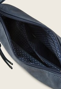 Dunkelblaue Clutch aus strukturiertem Leder, mit einem Reißverschluss und gepunktetem Futter sowie zwei separaten Fächern im Inneren.