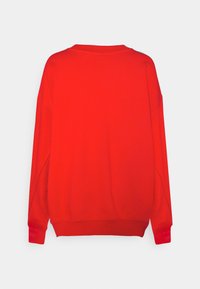 Sweatshirt rouge uni à manches longues avec des poignets et un ourlet côtelés, présenté de dos sur un fond blanc.