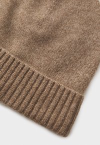 Pruun kudumisega beanie, millel on soonikserv. Pehme tekstuur, millel on kerge heatheriga viimistlus, näidates erinevaid pruunide toone.