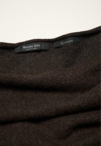 Sciarpa di cashmere marrone con una morbida texture, caratterizzata da etichette del marchio che leggono "Massimo Dutti" e "100% Cashmere." Design piegato visibile.