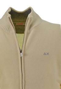 Maglione beige con zip, colletto a coste, con un logo sul petto sinistro e una texture morbida. Strato interno di colore verde chiaro.