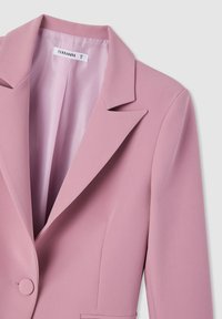 Blazer rosa con rever a punte, chiusura a un bottone e foderatura interna liscia. Presenta spalle strutturate e una lieve texture.