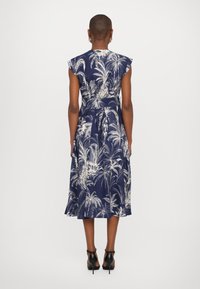 Rochie bleu marina cu model de frunze de palmier albe, cu mâneci scurte în clopot, talie strânsă și fustă evazată, terminată cu un cordon de legat.