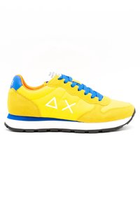 Žluté semišové a síťované tenisky s modrými šňůrkami a akcenty. Mají bílé grafické logo a lehkou černou gumovou podrážku.