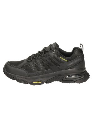 Zapatilla negra con materiales de malla y sintéticos. Cuenta con un diseño repelente al agua, suela acolchada y suela de caucho Goodyear.