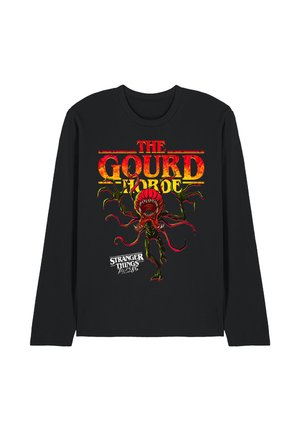 Schwarzes Langarmshirt mit orange-gelbem Text "The Gourd Horde" und einer rot-grünen Monster-Grafik, dazu der Schriftzug "Stranger Things Tales 85" darunter.