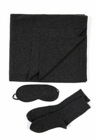 Mörkgrå filt, ögonmask och strumpor i mjukt material. Filten är vikt prydligt och visar en slät textur; tillbehören matchar i färg.