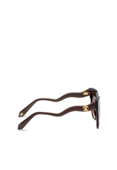 Lunettes de soleil marron avec des branches texturées en forme de serpent et des logos décoratifs dorés près des charnières, présentées en vue latérale sur un fond blanc.