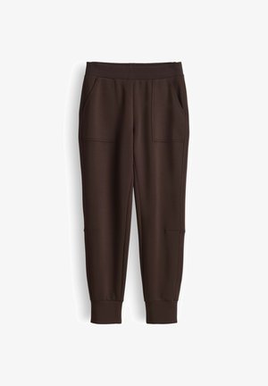Pantaloni jogger marrone scuro con fascia elastica in vita, tasche applicate frontali e polsini a coste alle caviglie, mostrati distesi su sfondo bianco.