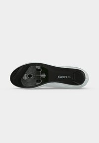 Semelle d'une chaussure de cyclisme blanche montrant une zone de fixation noire avec des marques de réglage et le logo Giro Sport Design.