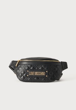 Mustast tikitud nahast Love Moschino vöötask kuldse tõmbluku ja logoplakaadiga ees ühevärvilise tausta ees.