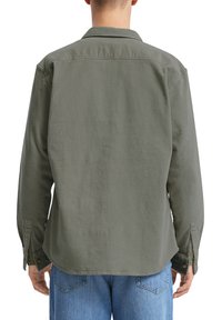 Langsleeve shirt in olijfgroen, gestructureerde stof, rechte snit, gebogen zoom en met knopen aan de manchetten. Geen zichtbare logo's of bijzondere kenmerken.