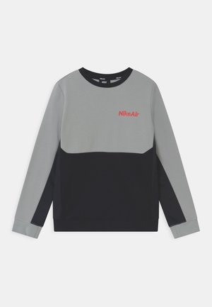 Sweat-shirt Nike Air à manches longues avec moitié supérieure grise, moitié inférieure noire et logo rouge sur la poitrine sur fond blanc.