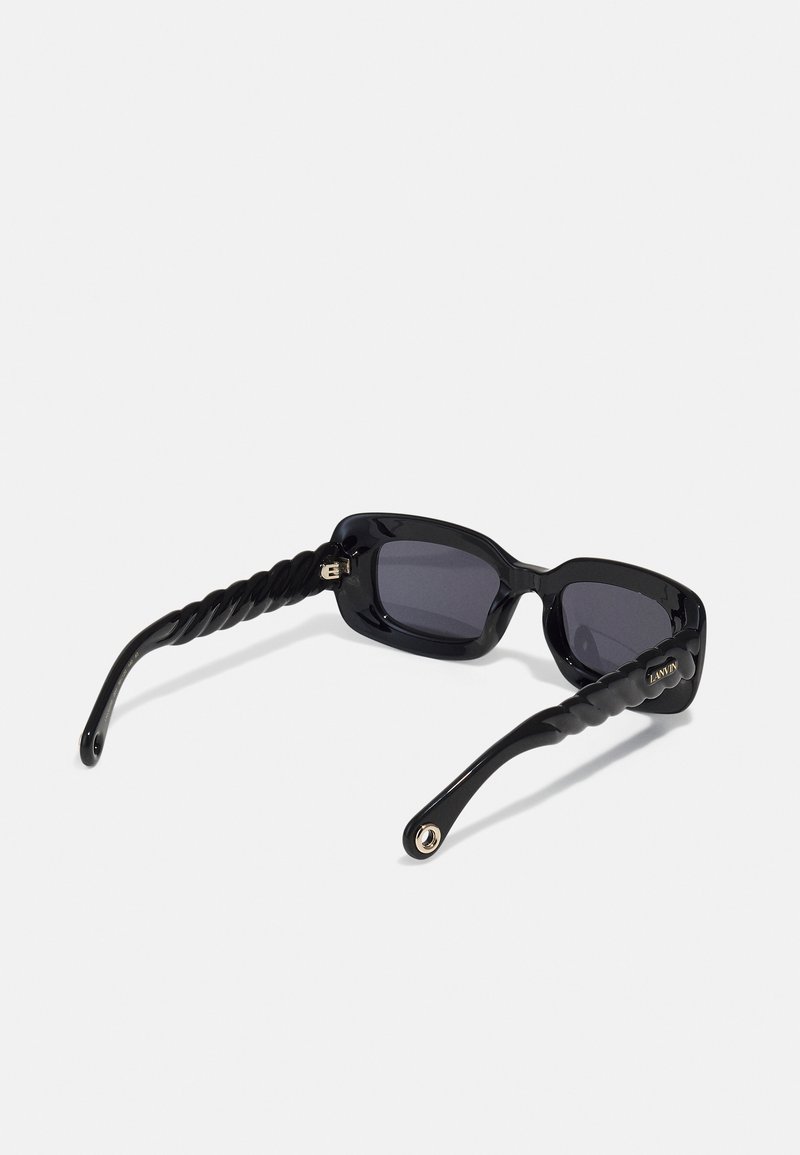 Black sunglasses with a chunky square frame, twisted black temple arms, tinted lenses, and gold hardware detail featuring the brand name.