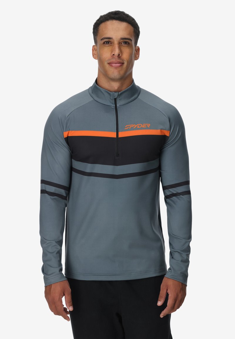 Grijze sportieve pullover met halve rits en hoge kraag, voorzien van gedurfde oranje en zwarte horizontale strepen over de borst en mouwen.