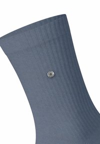 Calza a coste di un blu scuro con dettaglio di bottone argento. Presenta una soffice texture e un design che arriva a metà polpaccio.