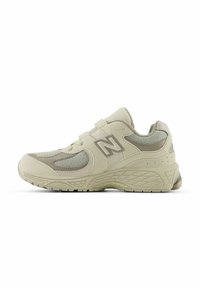 Beige athletic shoe with mesh and suede upper, dual Velcro straps, textured midsole, and rubber outsole with a geometric pattern.