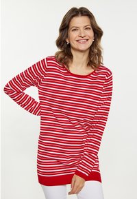 Maglione a righe rosse e bianche con maniche lunghe, scollatura tonda e vestibilità comoda, caratterizzato da un bordo e polsini a coste.