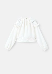 Blusa bianca a maniche lunghe con spalle arricciate, tessuto testurizzato e chiusura con bottoni sul retro. Presenta dettagli decorativi a occhio di pernice.