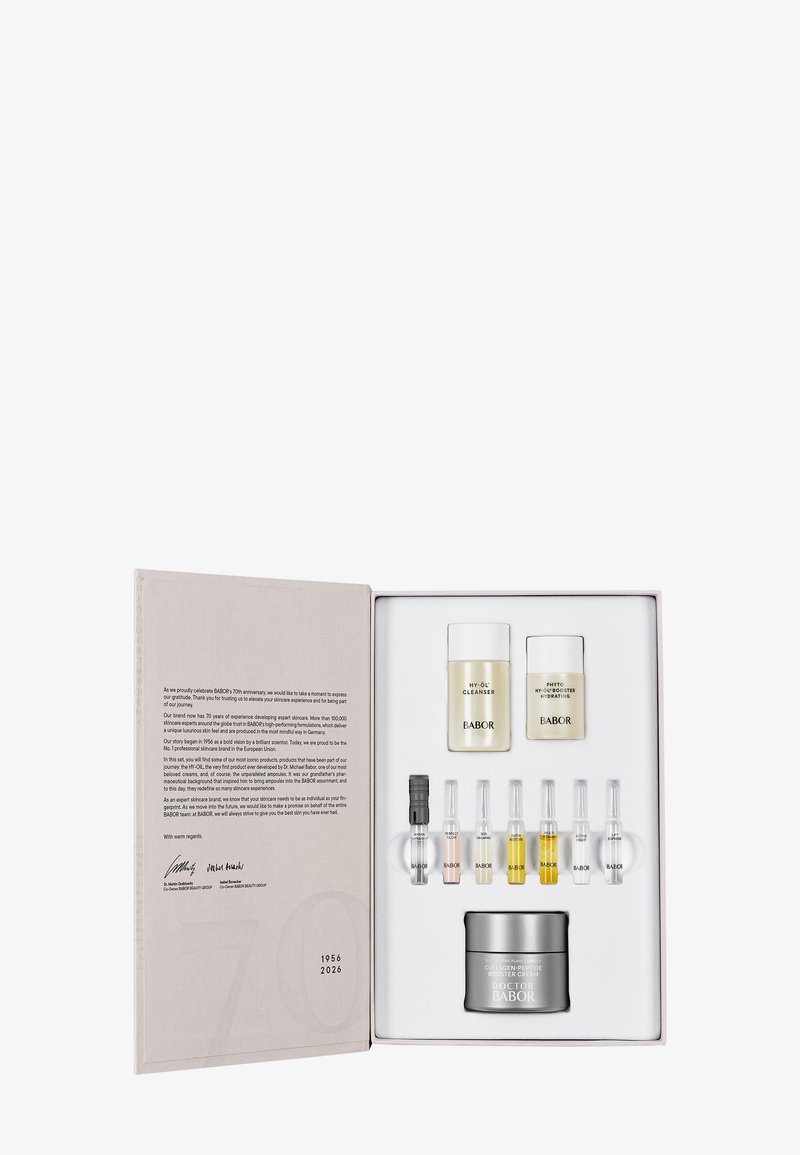 Set de cuidado de la piel Babor en una caja gris claro que incluye dos frascos blancos, siete ampollas de vidrio y una lata plateada, todos dispuestos sobre un inserto blanco.