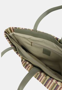 Borsa a strisce intrecciata con manici in ecopelle verde, chiusura con zip e interni in stoffa beige con una piccola tasca con zip.