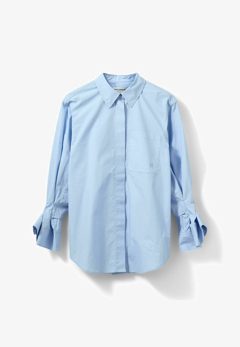 Chemise bleu clair à manches longues boutonnée, col pointu et poche poitrine, étalée à plat avec les manches légèrement pliées.