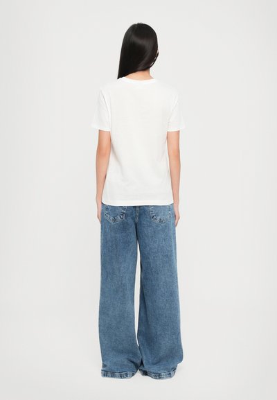 White cotton t-shirt with a round neckline paired with wide, light blue denim jeans featuring back pockets and a relaxed fit.