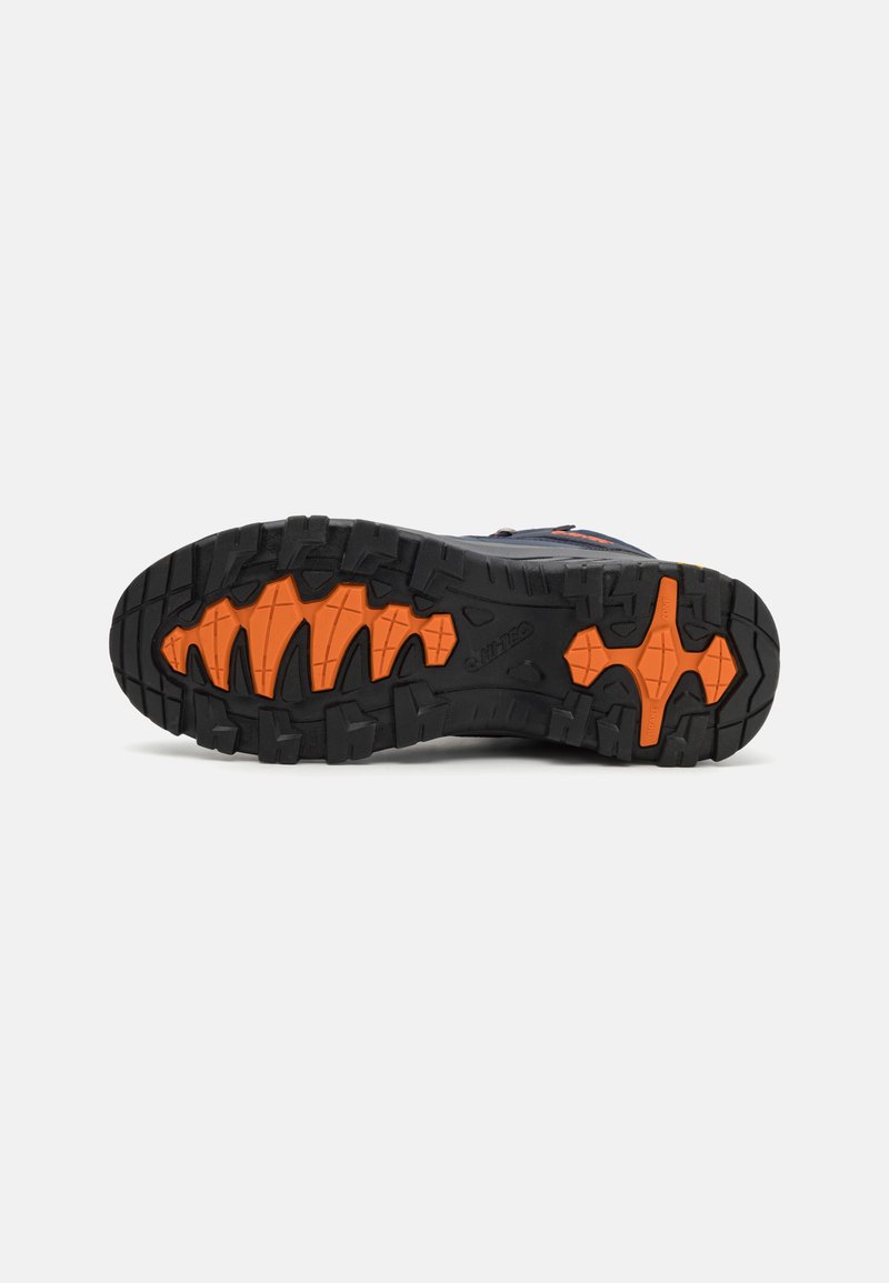 Sola di scarpe da trail con treads aggressivi per trazione, con una base nera e accenti arancioni vivaci. Costruzione in gomma durevole.