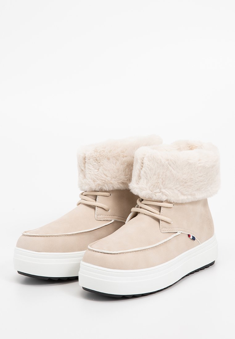 Bottines en suède beige avec un revers en fausse fourrure, semelle intermédiaire texturée blanche et semelle extérieure en caoutchouc gris. Comprend des lacets et des accents de couture.