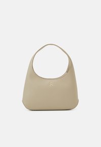 Beige skuldertaske i læder med buet design, en glat tekstur og et guldfarvet logo på forsiden.