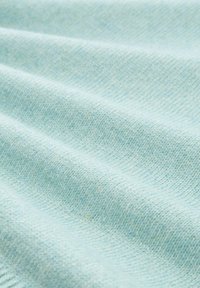 Jasnoniebieska tkanina o miękkiej, teksturowanej powierzchni, z pofałdowanym wzorem i subtelnymi odcieniami koloru na całej powierzchni.