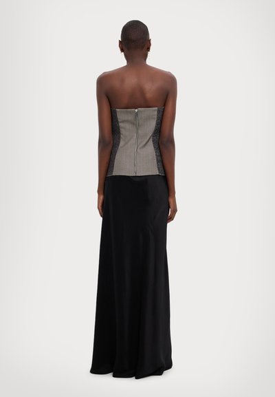 Zwarte maxi-jurk met een aansluitende grijs- en zwart-geweven lijfje, voorzien van een rits aan de achterkant en een strapless ontwerp.
