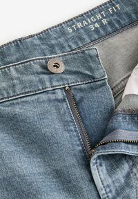 Jeans denim cu croială dreaptă, de culoare albastru deschis, cu fermoar și închidere cu nasture, și cusături contrastante. Etichetate cu mărimea 34 R.