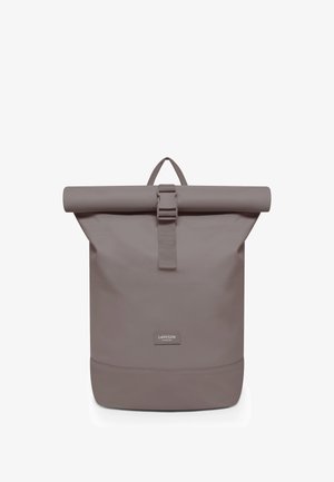 Rucsac roll-top minimalist taupe cu chingă frontală cu cataramă și etichetă Larkson Hamburg aproape de bază, stând vertical pe un fundal alb.