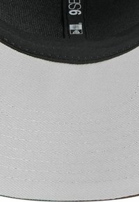 Graue Baseballkappe mit einem leicht geschwungenen schwarzen Schirm. Strukturiertes Material, verstärkte Nähte und ein Innen-Schweißband für zusätzlichen Komfort.