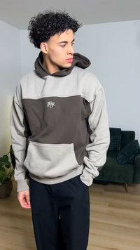 Φούτερ με κουκούλα σε γκρι και σκούρο καφέ, με μπροστινή τσέπη και λογότυπο. Απαλό ύφασμα με άνετη εφαρμογή και μακριά μανίκια.