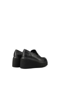 Scarpe platform nere in pelle con una texture liscia e forma arrotondata. Presentano un tacco a cuneo spesso e un design minimalista.