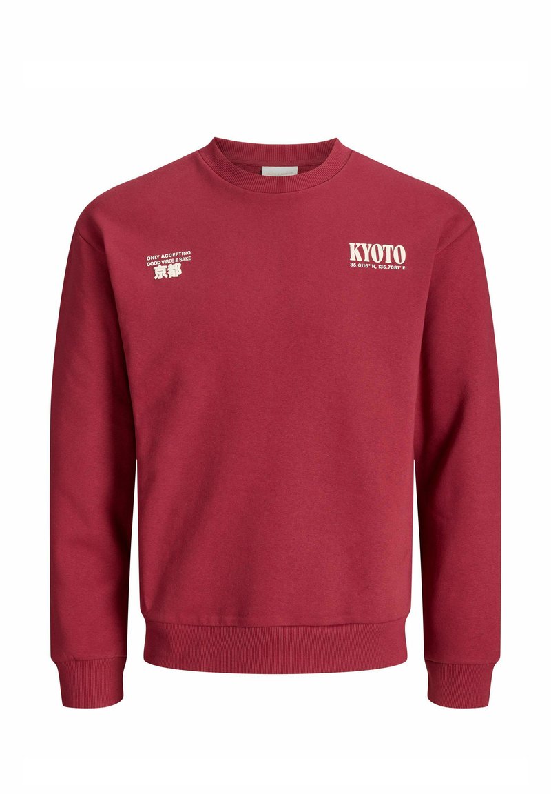 Rode katoenen sweatshirt met lange mouwen. Heeft witte tekstafbeeldingen: "KYOTO", coördinaten, en "ALLEN GOEDE VIBRATIES GEACCEPTEERD." Klassieke ronde hals.