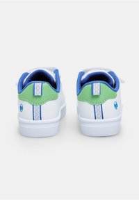 Ein Paar weiße Sneakers mit grünen Fersenelementen, blauer Innenausstattung, gemusterten Zugschlaufen und blauem, rundem Logo auf der Rückseite.