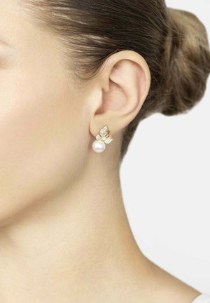 Goldene Schmetterlingsohrringe mit klaren Edelsteinakzenten und einer zentralen weißen Perle, die ein zartes Design mit filigranen Details zeigen.