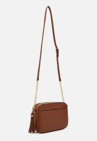 Brązowa syntetyczna torba na ramię o prostokątnym kształcie, z złotymi łańcuszkami i ozdobą w postaci frędzla po boku. Regulowany pasek pozwala na dostosowanie długości.