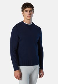 Pull en maille bleu marine avec texture en côtes sur les manches et l'ourlet, présentant un col rond et des détails subtils aux épaules.