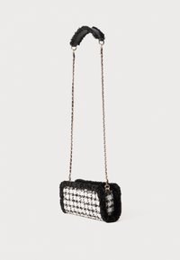Borsa in tweed bianco e nero con bordi morbidi simili alla pelliccia, forma rettangolare, tracolla in catena dorata e superficie texturizzata.