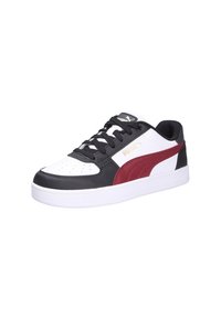Zapatilla baja blanca con superposiciones negras, franja roja de Puma en el lado, cordones negros y suela blanca.