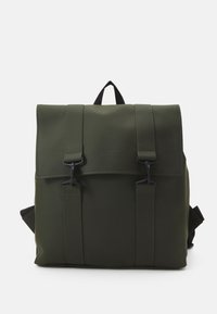 Sac à dos imperméable vert avec un design à rabat, comportant des éléments noirs, deux sangles avant et une poignée supérieure pour le transport.