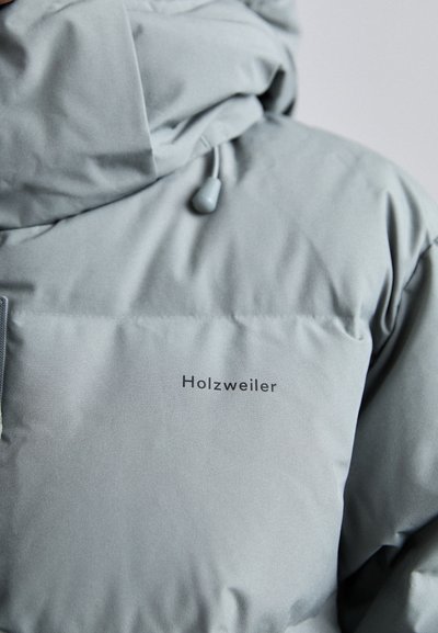 Light gray padded jacket with a hood, featuring a logo in black text on the chest. Smooth texture and adjustable drawstring at the neckline.