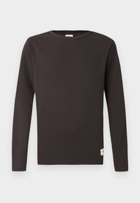 Duga majica s dugim rukavima u tamnosmeđoj boji, izrađena od rebrastog pamuka. Ima okrugli izrez, ravni kroj i mali oznaku na donjem rubu.