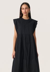 Schwarzes Baumwollkleid mit Rüschenärmeln, gefälteltem Oberteil und Stufen. Mit einem Spitzenbesatz am Ausschnitt und einem strukturierten Stoffdesign.
