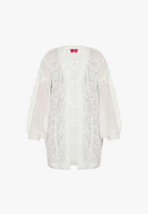 Fehér kötött kardigán V-kivágással, nyitott elülső résszel és háromnegyedes ujjakkal. Részletes csipkés mintákkal és texturált dizájnnal rendelkezik.