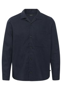 Camisa de manga larga azul marino con cierre de botones, cuello y bolsillo en el pecho. Fabricada con un tejido texturizado y un corte relajado.